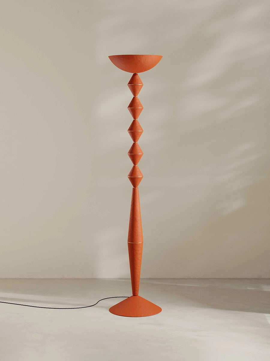 Geometric floor lamp in orange against a plain background